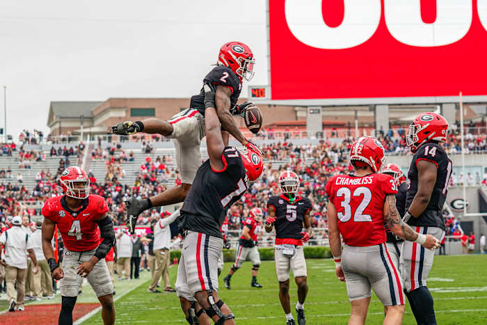 Georgia Bulldogs running back Kendall Milton gets lifter by offensive lineman Devin Willock in the air after scoring in Georgia’s spring game